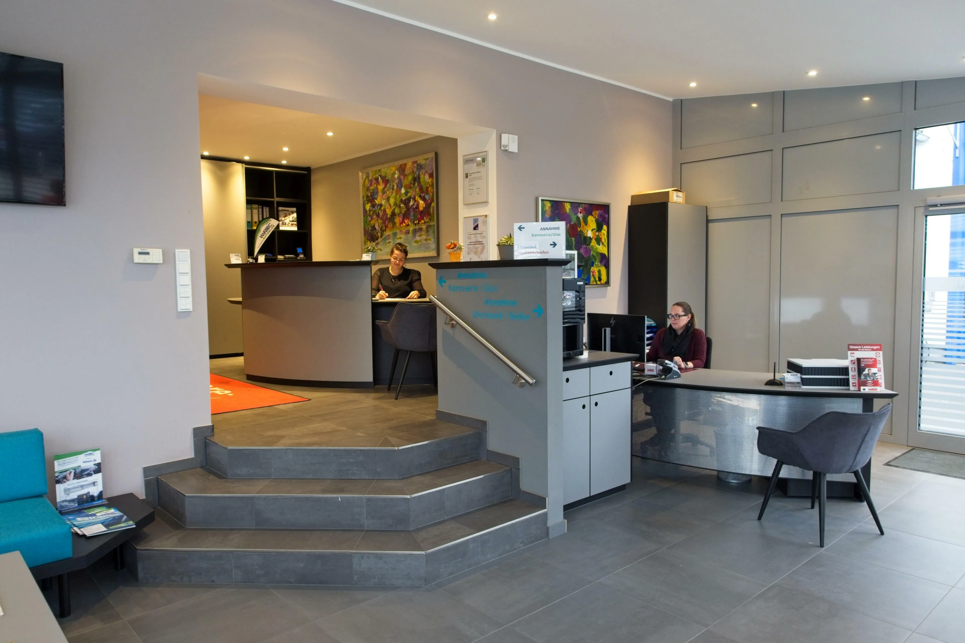 Anmeldung an unserem freundlichem Empfang Das Bild zeigt den neugestalteten Empfangsraums für Kunden mit den Damen an den Empfangstheken