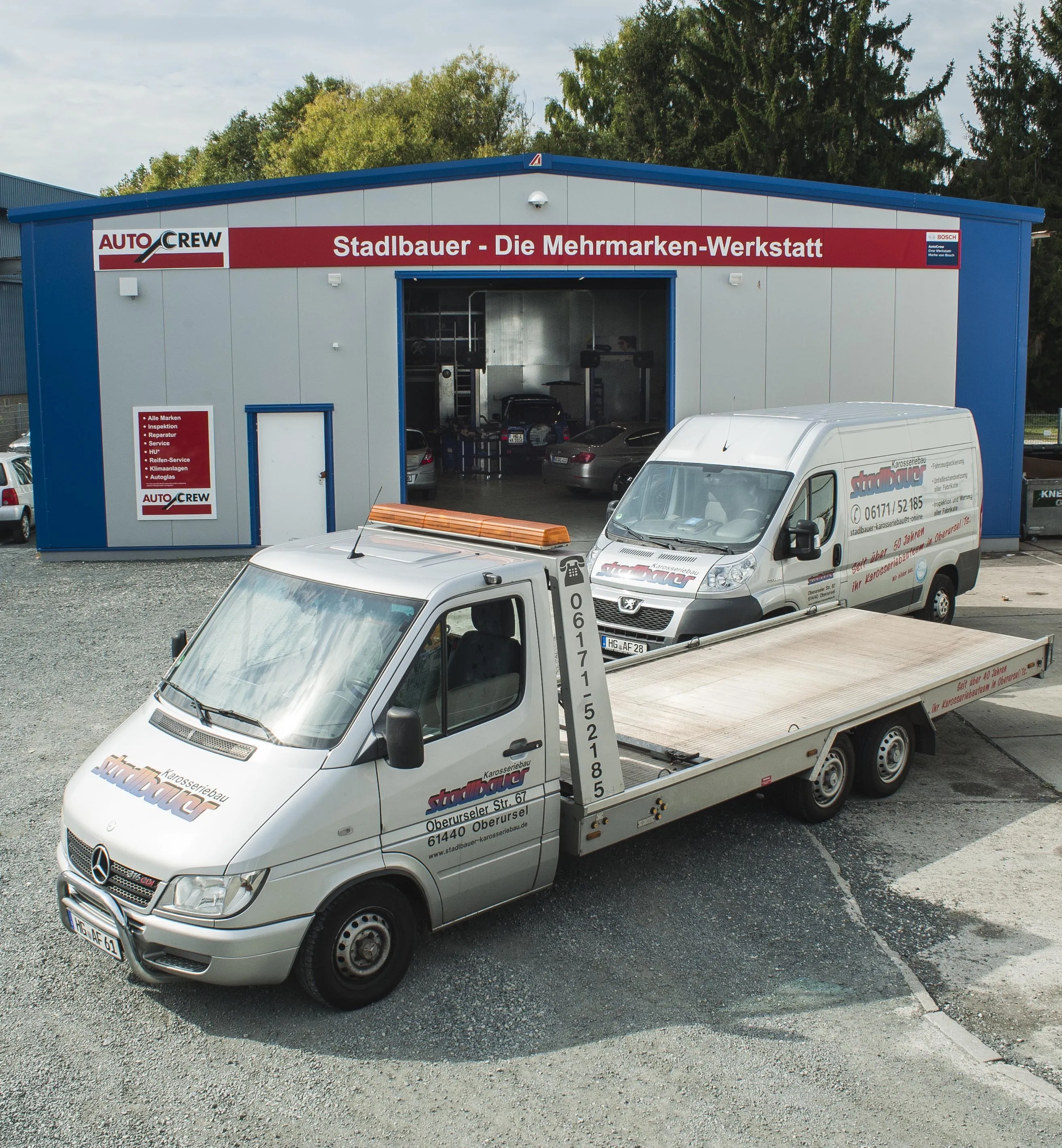 Unsere Autowerkstatt-Halle und Servicefahrzeuge Es ist die neue Autowerkstattshalle zu sehen und davor steht der Abschleppwagen und ein Servicefahrzeug